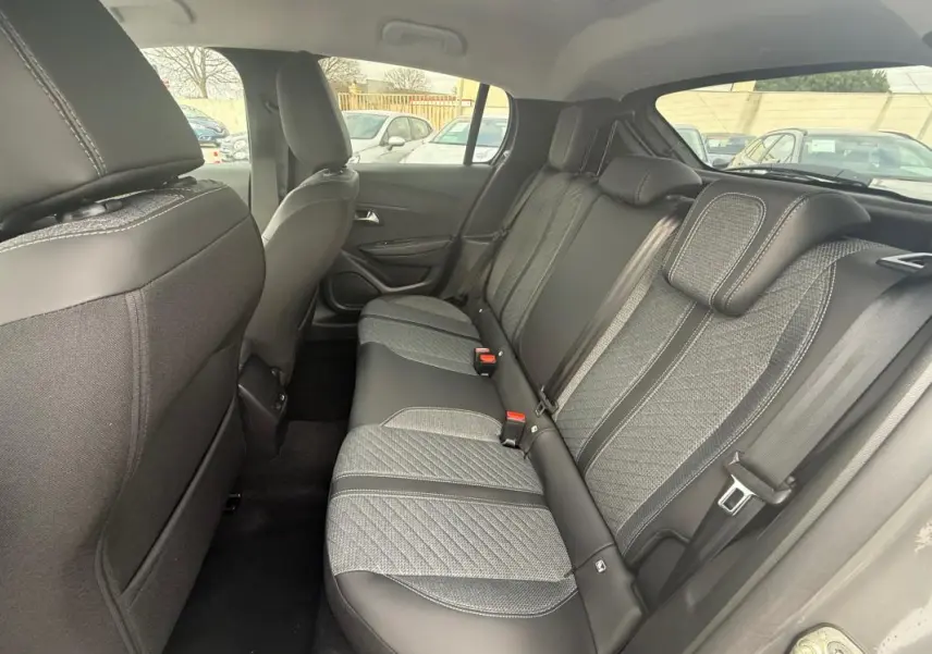 Vue intérieure côté droit des sièges arrière gris avec surpiqûres contrastées de la Peugeot 208 Hybrid 145 Allure 2025.