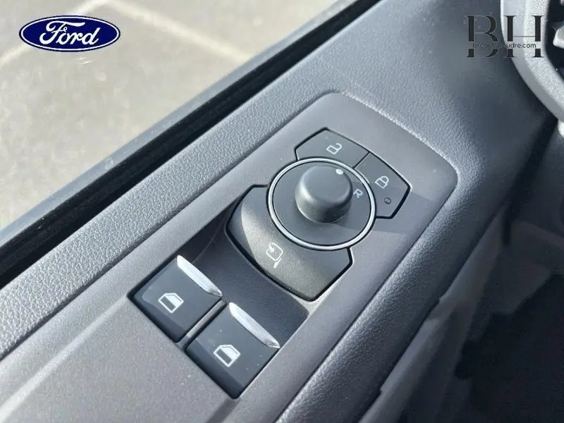 Gros plan sur les commandes électriques des vitres et rétroviseurs côté conducteur du Ford Transit Custom gris Magnetic.