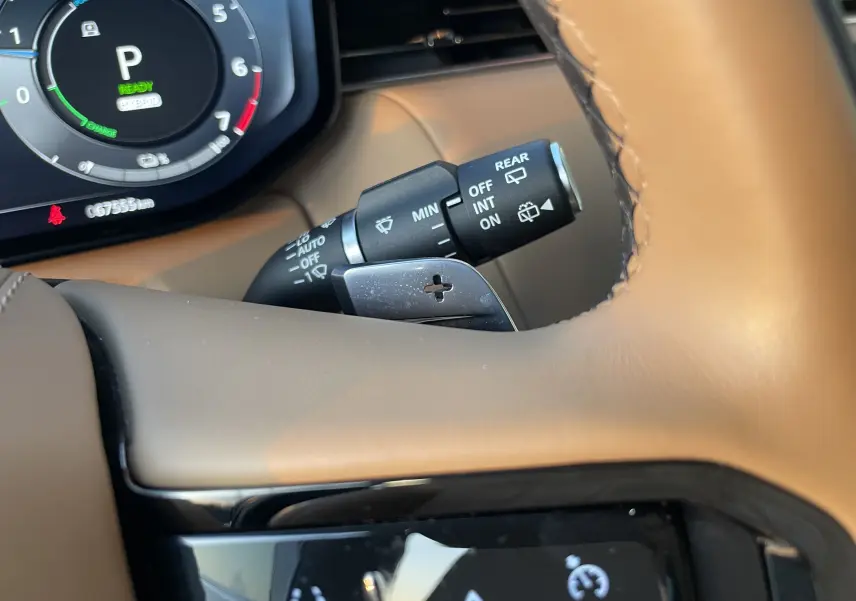 Gros plan sur le volant beige du Range Rover Sport P440 HSE R-Dynamic avec palettes de changement de vitesse et tableau de bord numérique.