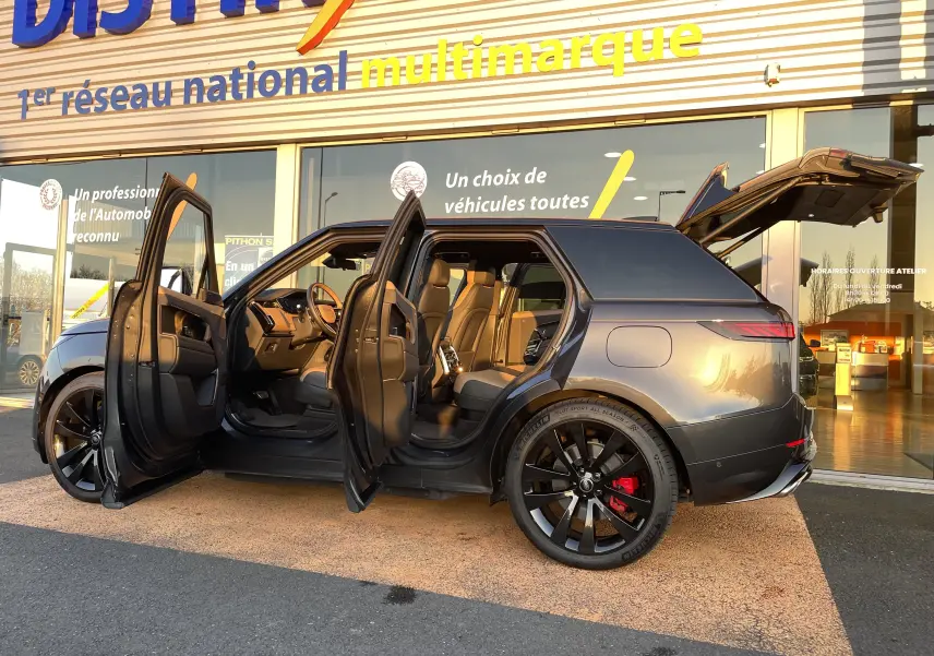 Vue latérale droite d’un Range Rover Sport P440 HSE R-Dynamic gris Carpathian, portes et coffre ouverts, jantes noires 23'' et étriers rouges.