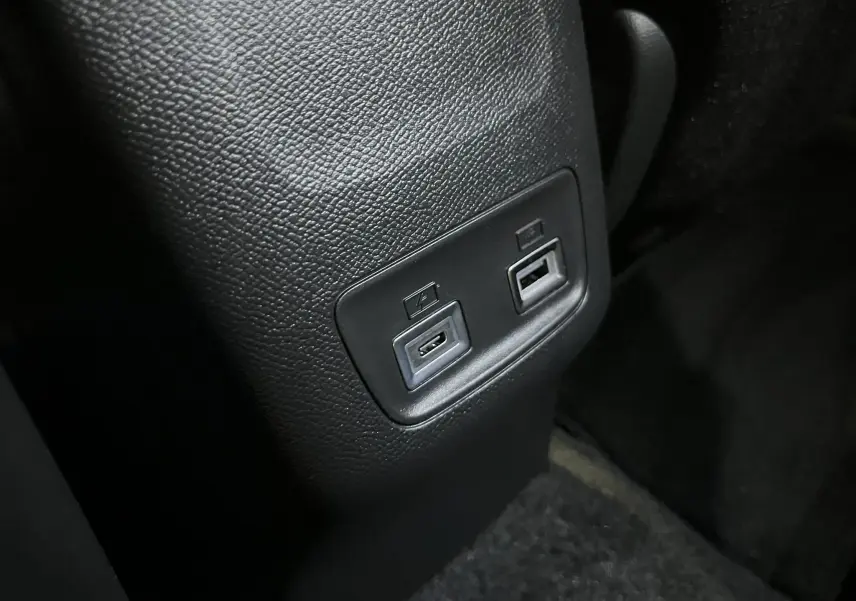 Gros plan sur les ports USB arrière intégrés dans la console centrale noire du Peugeot 2008 gris Artense 2025.