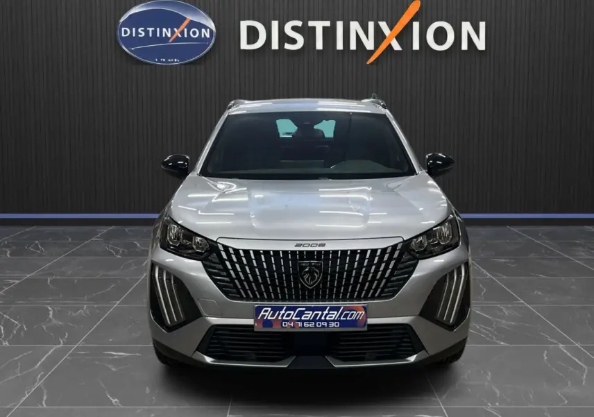 Peugeot 2008 gris Artense métal vue de face, soulignant la calandre verticale et les feux LED distinctifs.