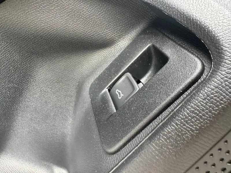 Gros plan sur le bouton d'ouverture du coffre noir dans l'habitacle du CUPRA Formentor 2.0 TDI 150ch V DSG7 Noir Minuit.