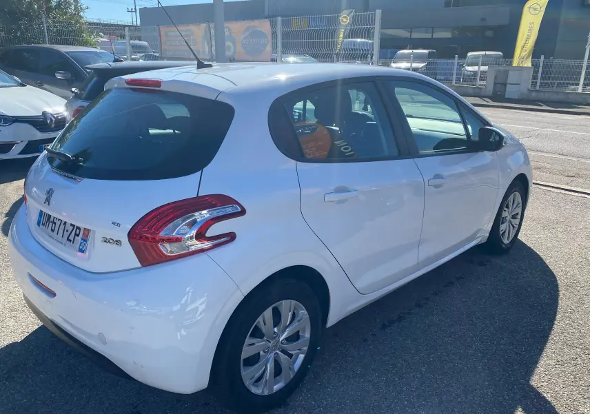 Peugeot 208 blanche vue en 3/4 arrière côté droit, avec feux arrière distinctifs et cinq portes visibles.