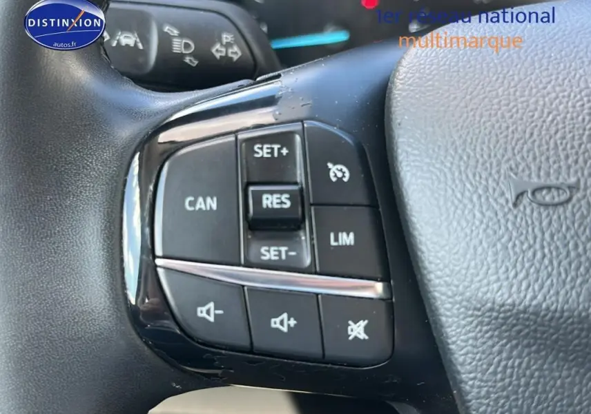 Gros plan sur les commandes du régulateur de vitesse et du volume au volant d'une Ford Focus Active gris foncé 2021.