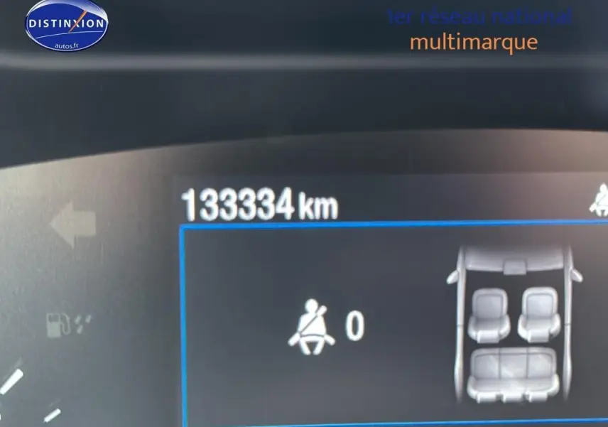 Vue rapprochée du tableau de bord numérique d'une Ford Focus Active gris foncé affichant 133334 km et l'état des ceintures.