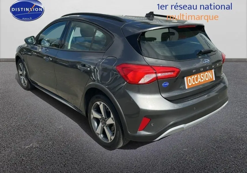 Vue 3/4 arrière droite d'une Ford Focus Active gris foncé avec barres de toit et jantes alliage 17 pouces.