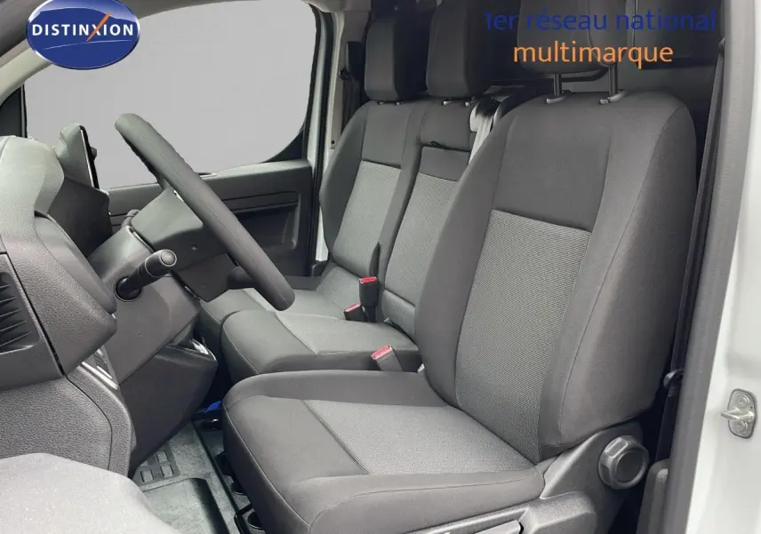 Intérieur avant du Peugeot Expert Fourgon blanc icy 2025, vue côté conducteur montrant les sièges gris et le volant.
