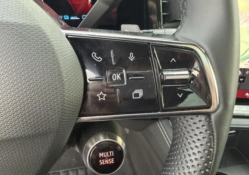 Gros plan sur les commandes au volant côté droit du Renault Austral 2025, volant en textile grainé noir.