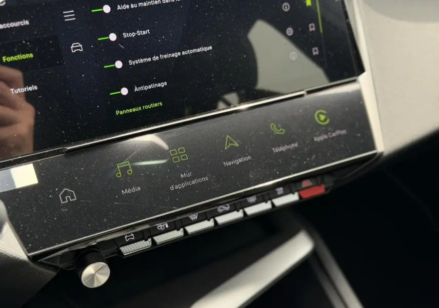 Gros plan sur la console centrale tactile du Peugeot 308 gris Artense, affichant les fonctions multimédia et navigation.