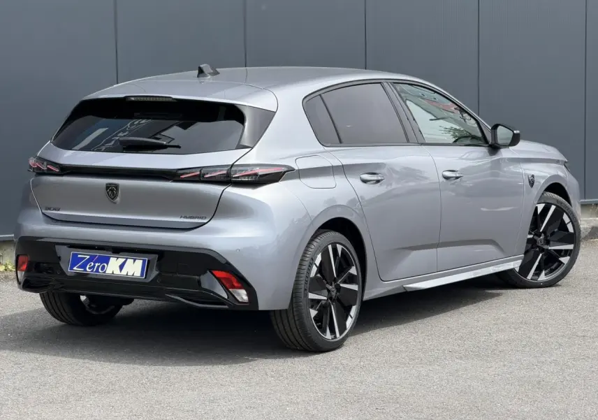 Peugeot 308 NV Hybrid gris Artense vue 3/4 arrière droit, jantes bi-ton et feux arrière LED 3 griffes.