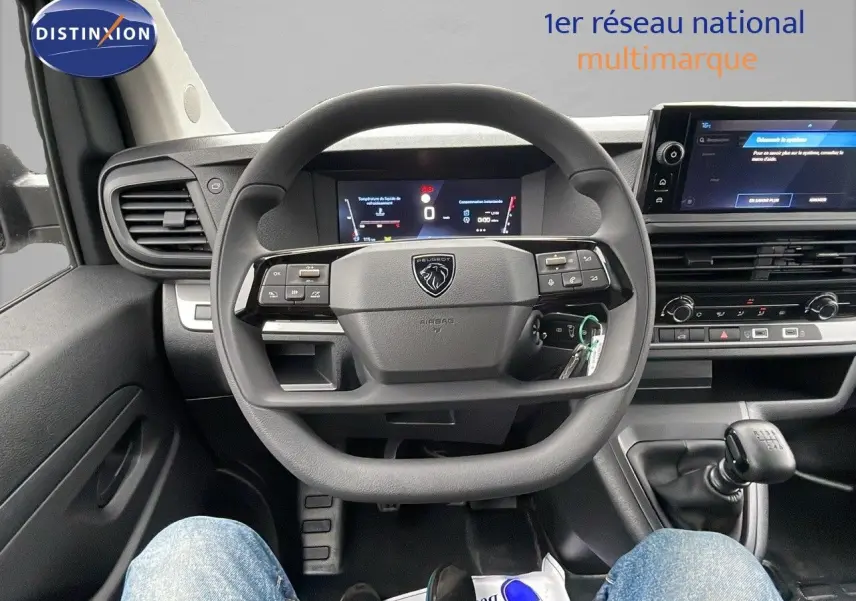 Vue centrée sur le volant et le tableau de bord du Peugeot Expert Fourgon blanc, avec levier de vitesse manuel visible.