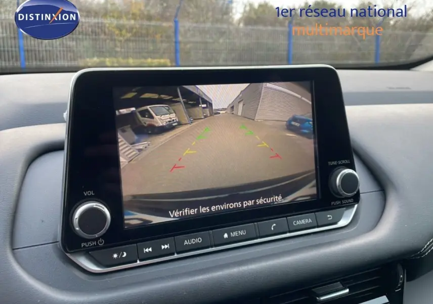 Écran central du Nissan Qashqai 2023 montrant la caméra de recul avec guidage coloré, intérieur noir.