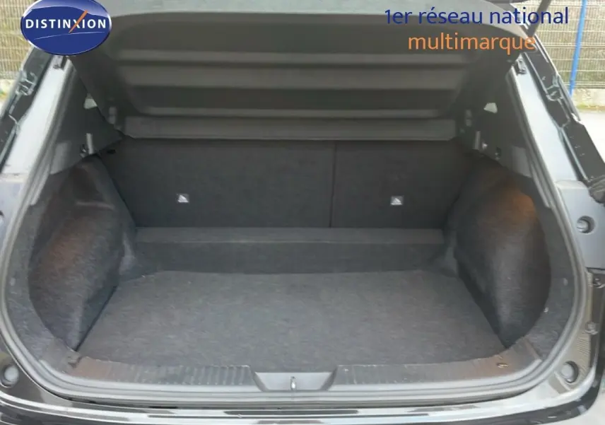 Coffre ouvert d'un Nissan Qashqai noir métal 2023, vue arrière montrant l'espace de chargement vide et propre.