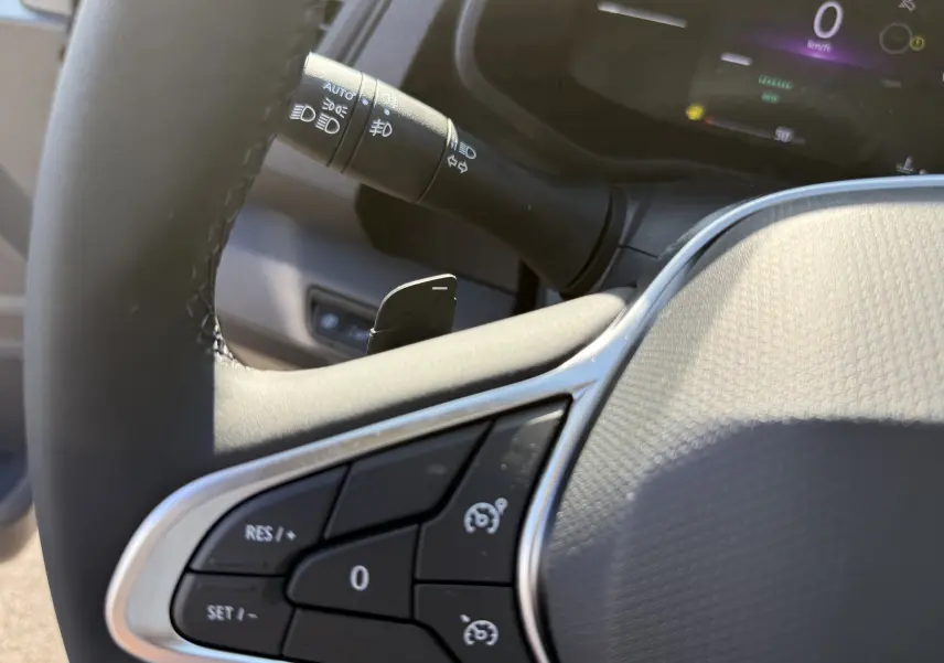 Détail du volant noir du Renault Trafic cabine approfondie 2025, avec commandes de régulateur de vitesse et levier de clignotant.