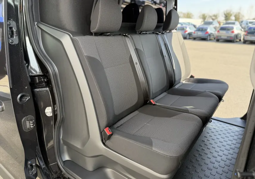Vue latérale intérieure montrant la banquette arrière noire du Renault Trafic Cabine Approfondie L2H1 2025.
