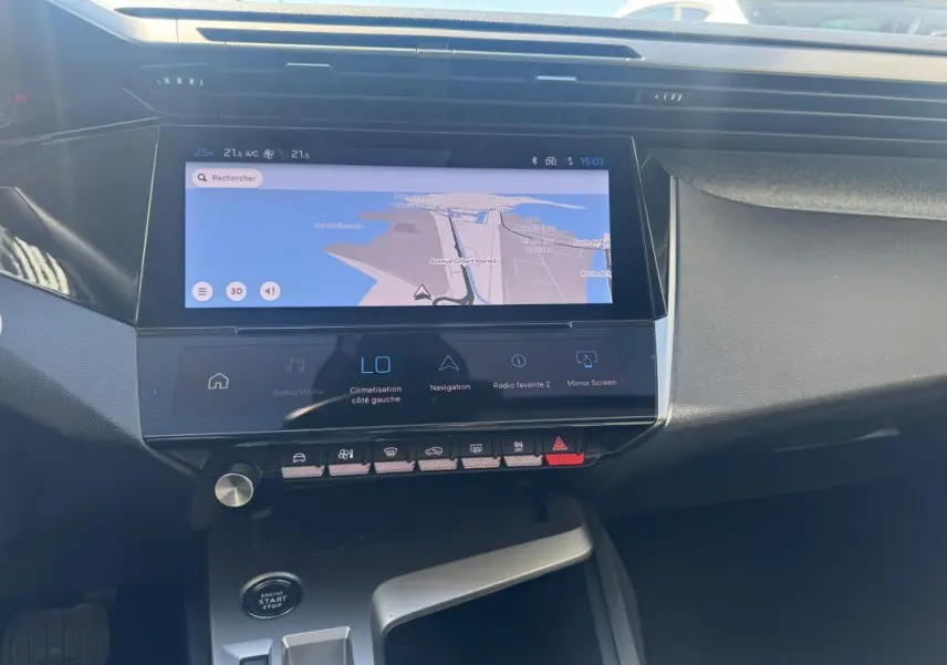 Vue rapprochée du tableau de bord de la Peugeot 308 Hybrid gris 2025, avec écran tactile de navigation et commandes tactiles.