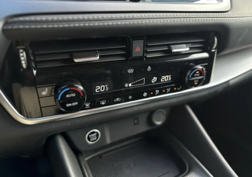 Gros plan sur la console centrale du Nissan Qashqai 2025, affichant la climatisation automatique bi-zone et les commandes tactiles.