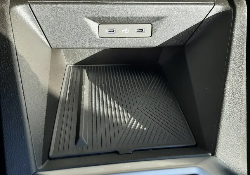 Gros plan sur la console centrale de la Renault Clio VI TCe 115ch Techno avec deux ports USB-C intégrés et un espace de rangement noir.