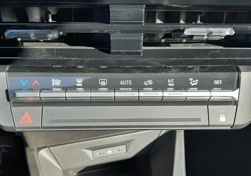 Gros plan sur la console de climatisation noire de la Renault Clio VI TCe 115ch Techno, avec commandes tactiles et voyants lumineux.