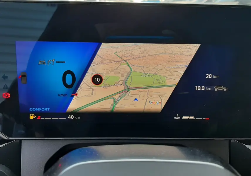 Affichage numérique du tableau de bord de la Renault Clio VI gris Rafale, montrant la navigation et les indicateurs de conduite.