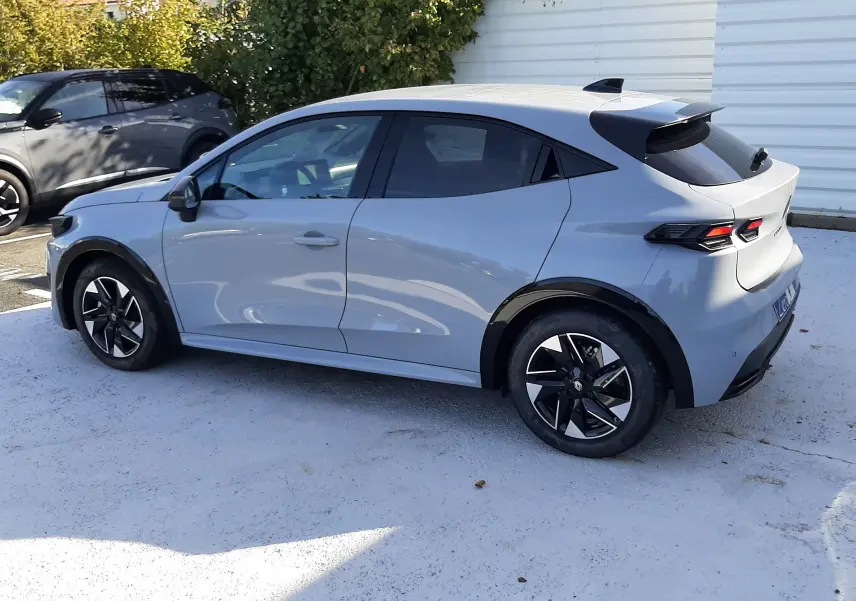 Renault Clio VI TCe 115ch Techno gris Rafale vue de profil côté gauche, avec jantes noires et toit noir contrasté.