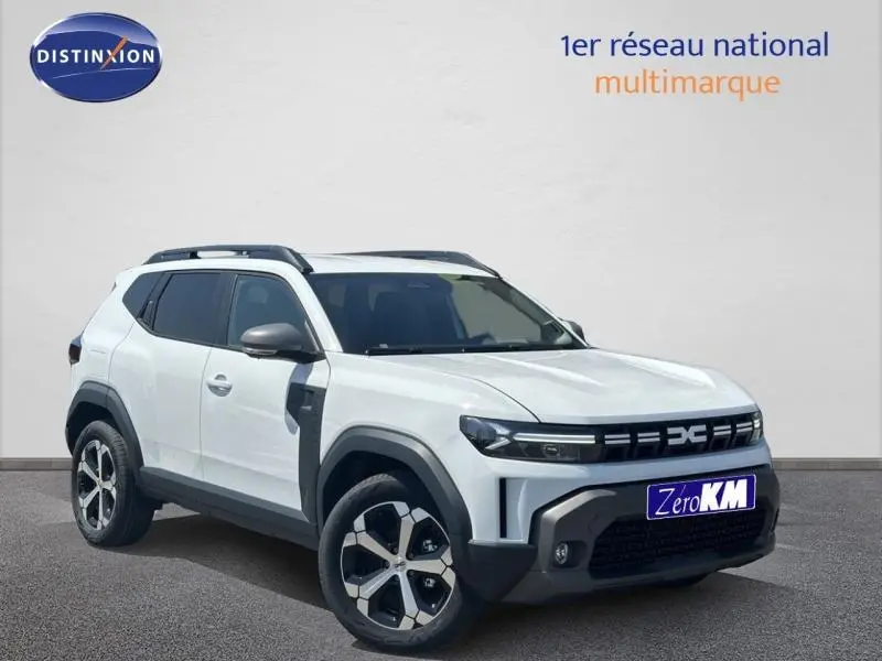 Vue 3/4 avant droite du Dacia Duster blanc Glacier avec jantes alu et barres de toit noires visibles.