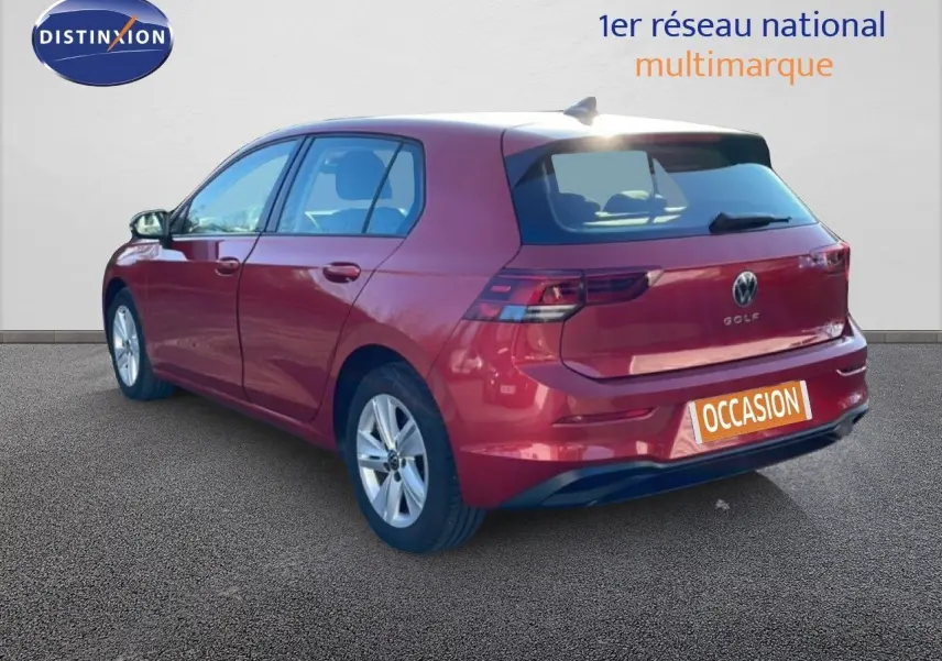 Vue 3/4 arrière droite d'une Volkswagen Golf VIII rouge Roi Metal avec jantes alliage et plaque "Occasion" visible.