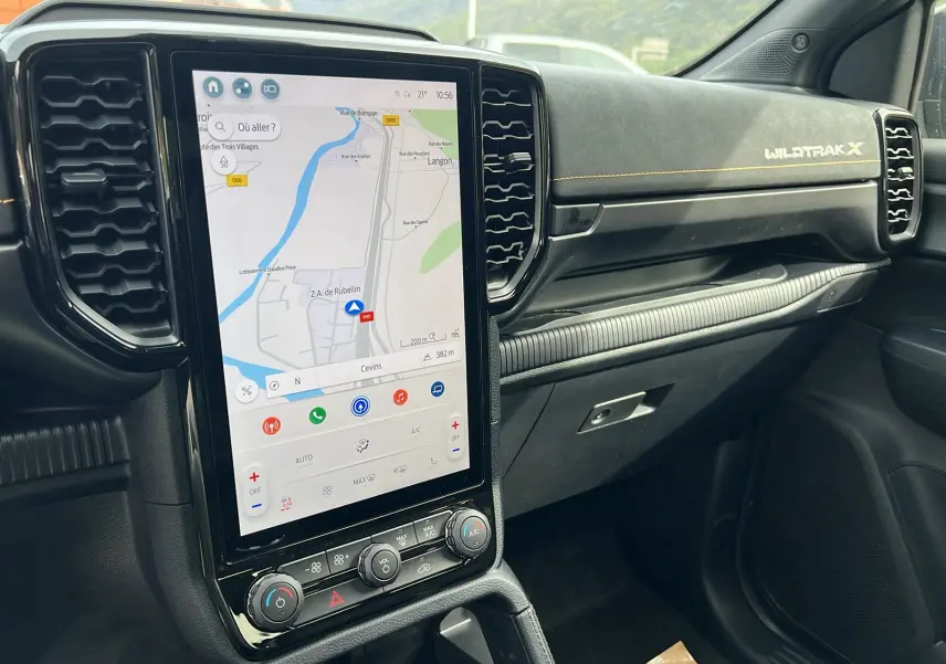 Vue intérieure côté passager du Ford Ranger Wildtrak X 2026, écran tactile GPS vertical et tableau de bord noir avec surpiqûres jaunes.