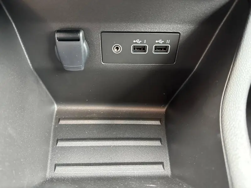 Gros plan sur les ports USB et prise 12V dans le rangement intérieur de la Renault Clio Gris Rafale 2025.