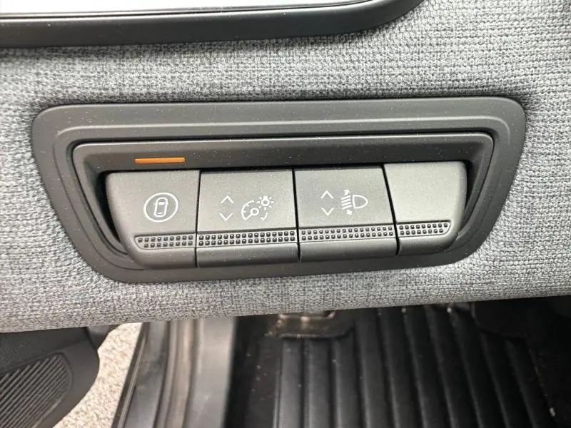 Détail des commandes d'éclairage et verrouillage sur tableau de bord avec finition textile gris dans Renault Clio 2025.
