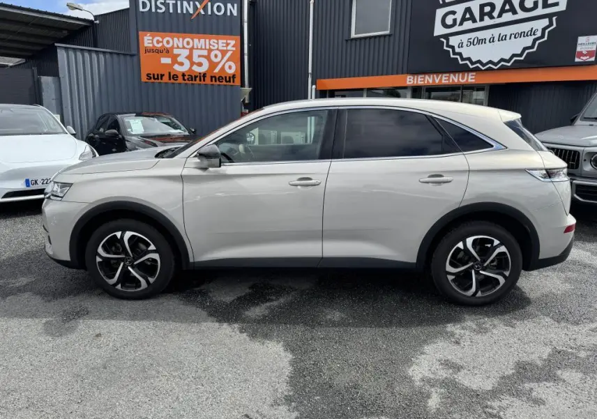 Vue latérale droite d'un DS7 Crossback gris métallisé 2022 avec jantes alliage noires et vitres teintées.