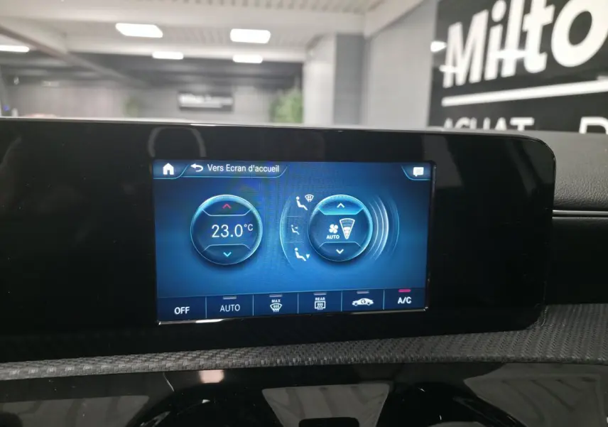 Écran tactile central de la climatisation affichant 23°C dans une Mercedes Classe A blanche de 2019.