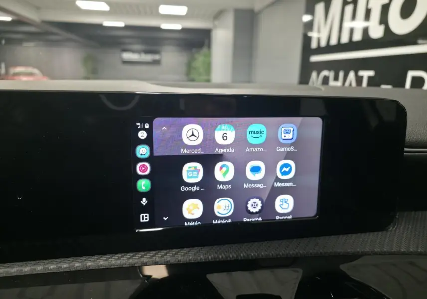 Écran tactile central MBUX affichant les applications smartphone dans l'habitacle de la Mercedes Classe A blanche.