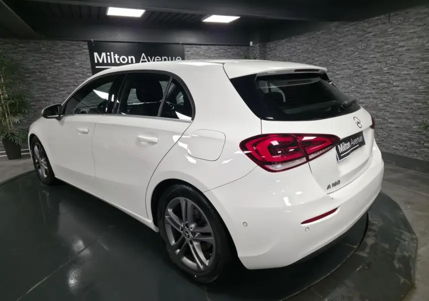 Mercedes Classe A 160 blanche vue 3/4 arrière droit, avec jantes alliage 17 pouces et feux arrière LED distinctifs.