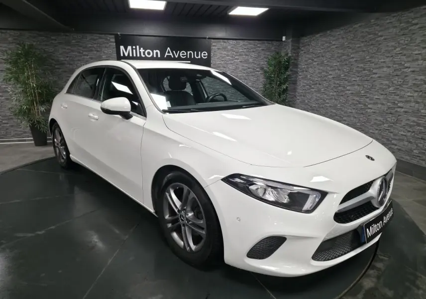 Vue 3/4 avant droite d'une Mercedes Classe A 160 Style Line blanche avec jantes alliage et calandre diamant.