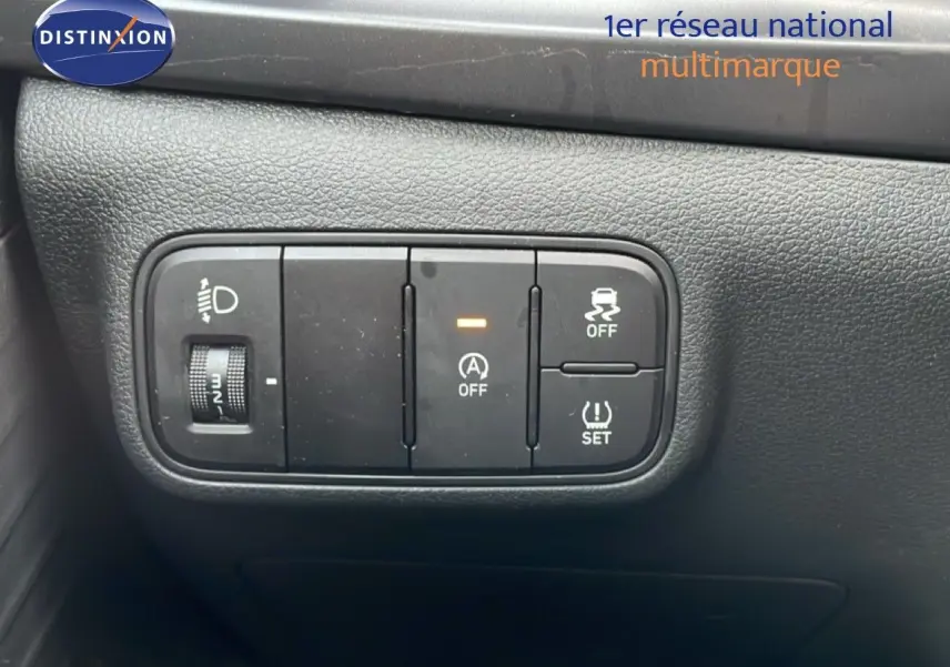 Gros plan sur les commandes de réglage des phares et d'assistance à la conduite dans l'habitacle d'une Hyundai i20 bleu vibrant metal.
