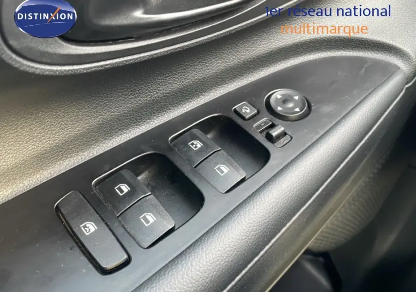 Gros plan sur les commandes des vitres électriques côté conducteur d'une Hyundai i20 2025, intérieur noir.