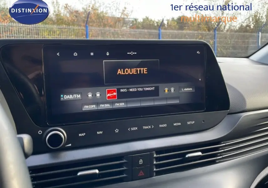 Vue intérieure du tableau de bord de la Hyundai i20 2025 avec écran tactile affichant la radio sur fond noir.