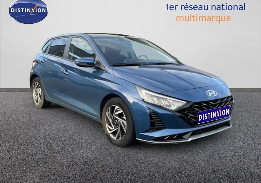Hyundai i20 2025 bleu vibrant métal vue 3/4 avant droit avec calandre noire et phares LED distinctifs.
