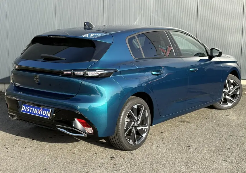 Vue 3/4 arrière droite d'une Peugeot 308 Hybrid 2025 en Bleu Obsession avec jantes alliage et vitres surteintées.