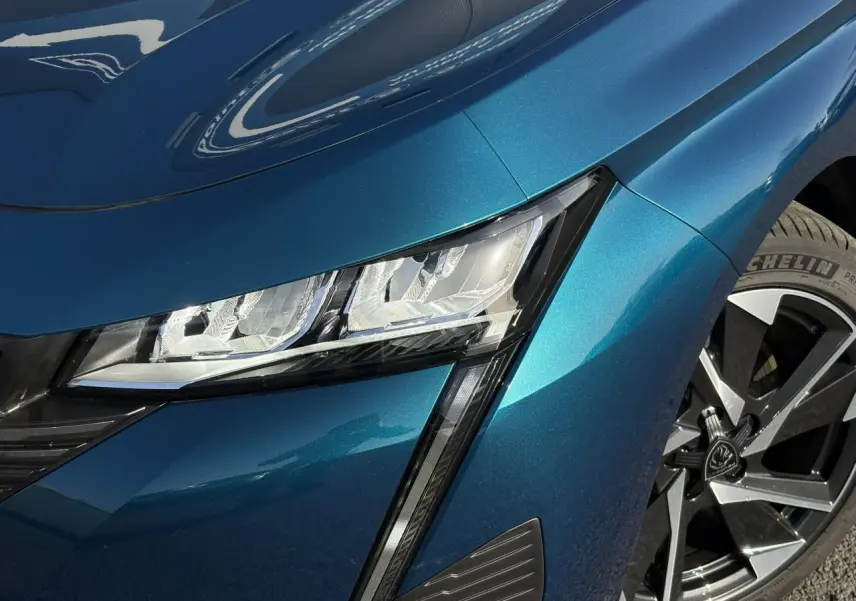 Gros plan sur le phare avant gauche et la jante alliage 17'' de la Peugeot 308 Hybrid Bleu Obsession.