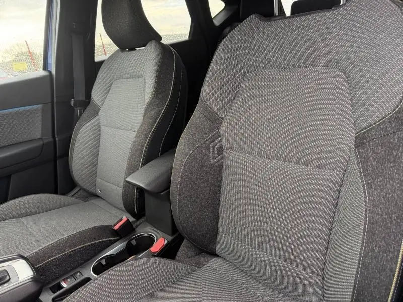 Vue rapprochée des sièges avant gris foncé du Renault Captur 2025 avec surpiqûres contrastantes et accoudoir central.