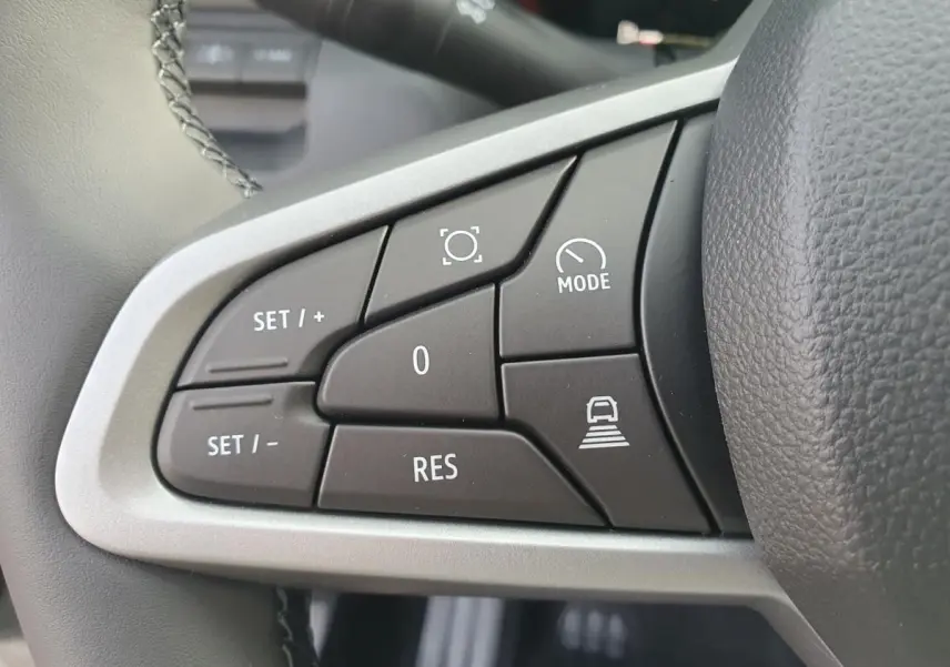 Gros plan sur les commandes de régulateur de vitesse au volant du Dacia Bigster, intérieur noir.