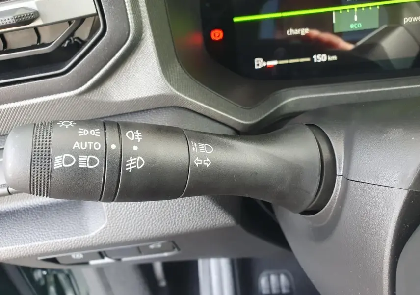 Gros plan sur la manette de commande des feux du tableau de bord du Dacia Bigster, intérieur noir.