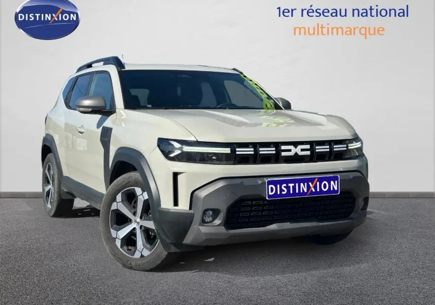 SUV Dacia Duster 2025 Sandstone en 3/4 avant, avec calandre noire distinctive et jantes alu bicolores.