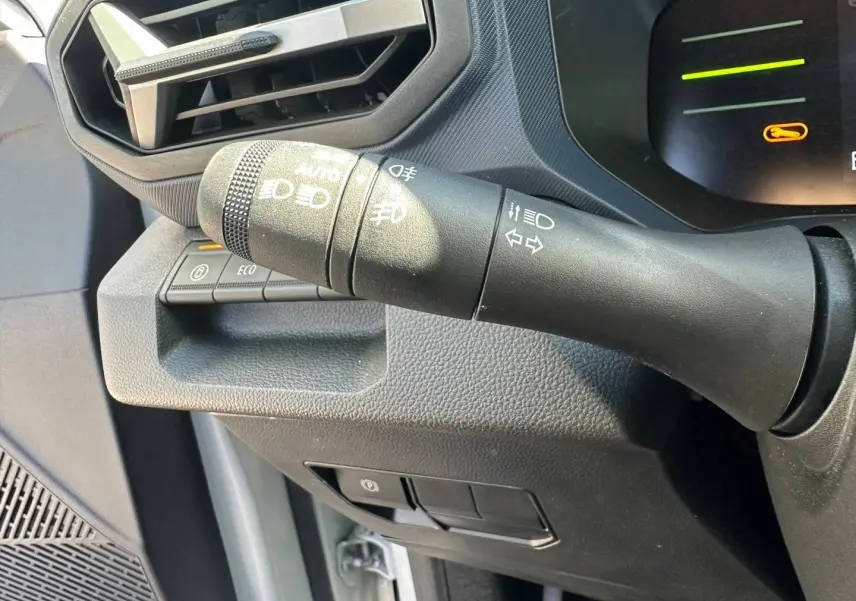 Gros plan sur la commande des feux et clignotants du Dacia Duster 2025 couleur Sandstone, intérieur noir.