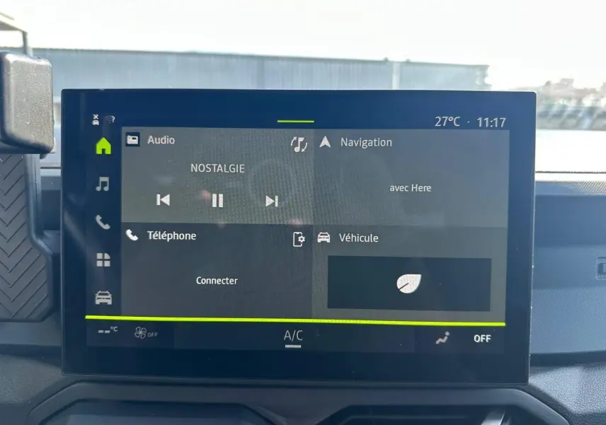 Écran tactile central du tableau de bord du Dacia Duster 2025, affichant les menus audio et navigation.