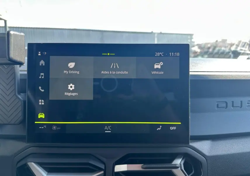 Écran tactile central du tableau de bord du Dacia Duster 2025 avec interface d’aides à la conduite visible.