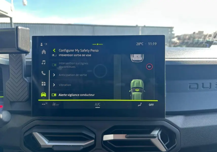 Vue intérieure du tableau de bord du Dacia Duster 2025 avec écran tactile affichant les réglages de sécurité.